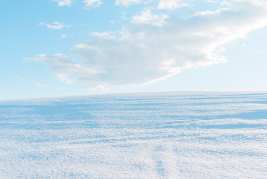 Freshly fallen snow and blue sky with clouds