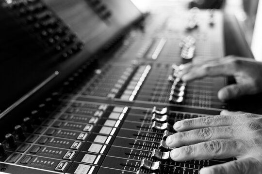 Sound engineer hands working on sound mixer in live concert. Black and White image