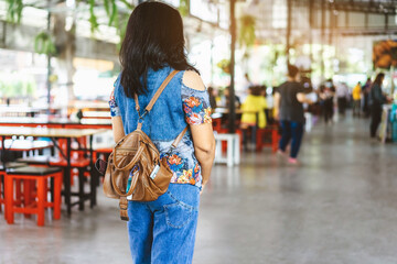 Mini portable alcohol gel bottle to kill Corona Virus(Covid-19) hang on a leather shoulder bag of a woman wear a protective mask at a cafeteria. New normal lifestyle. Selective focus on alcohol gel