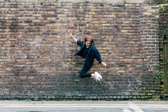 Woman jumping against a wall