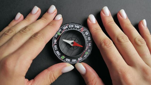 close up compass with moving needle on top on black background