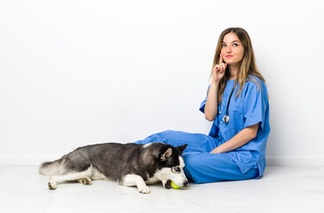 Veterinary doctor with Siberian Husky dog sitting on the floor thinking an idea