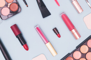 set of professional cosmetics, makeup tools and accessories on blue background, concept of beauty, fashion, shopping, flat lay