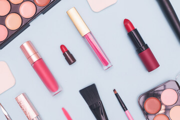 set of professional cosmetics, makeup tools and accessories on blue background, concept of beauty, fashion, shopping, flat lay