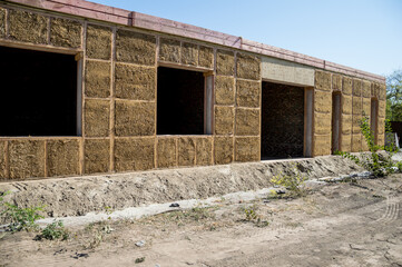 Construction of a house from an environmentally friendly material of plant origin. Frame made of wood, blocks of straw.