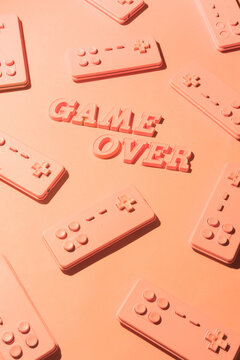 Gaming console josticks arranged with word ""Game over""