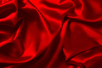 Red silk or satin luxury fabric texture can use as abstract background. Top view.