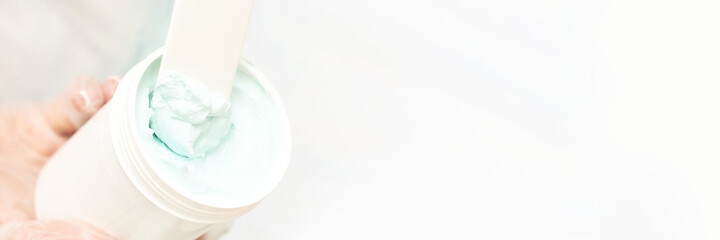 Portrait of moisturizing mask on white background for medical design. Woman skin procedure. Natural cosmetic products. Beauty face. Facial cosmetology treatment. Healthcare. Bowl with blue-green cream