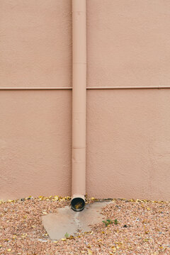 Adobe colored gutter pipe and autumn leaves