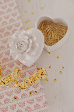 Heart-shaped ceramic box with golden clips on white table