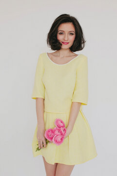 Young beautiful woman with bouquet of pink sanunculus