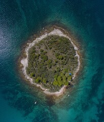 Vertical top view on a small island in the mediterrean sea close to the shore