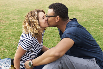 Interracial couple kissing in a park