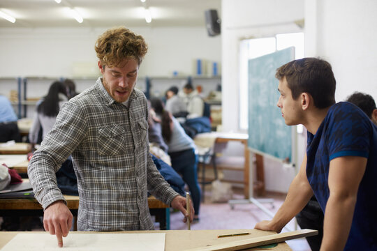 Two fellow students measuring a project for the engineering degree