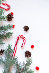 Christmas composition. Fir branches, cones, New Year's lollipop, red decorations on a white background. Christmas, winter, new year concept. Flat lay, top view, copy space