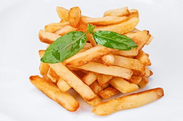 Heap of crispy fast-food french fries potato chips with basil leaves