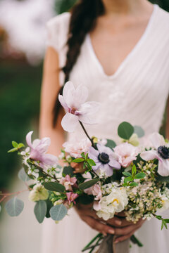 Long-haired brunette girl holds a flwers bouquet