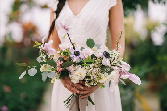 Long-haired brunette girl holds a flwers bouquet