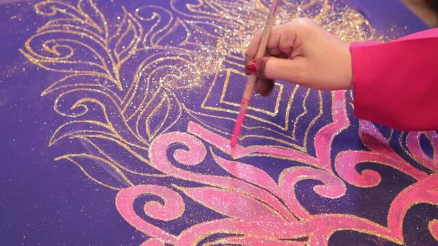 A woman painting on cloth using a brush