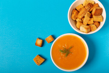 Pumpkin soup in a bowl with fresh dill herb