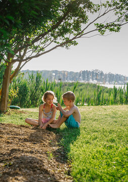 Young children relaxing inbackyard