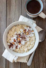 Oatmeal porridge with almonds, coconut and chocolate. Healthy eating. Vegetarian food. Breakfast. Diet.