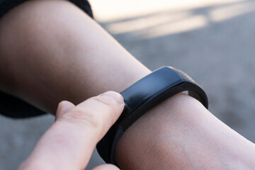 communication technologies concept- a woman uses her finger to adjust the smartwatch close-up