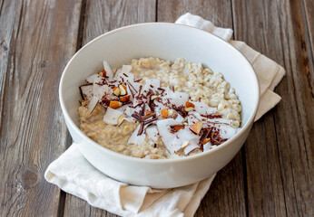 Oatmeal porridge with almonds, coconut and chocolate. Healthy eating. Vegetarian food. Breakfast. Diet.