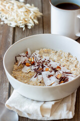 Oatmeal porridge with almonds, coconut and chocolate. Healthy eating. Vegetarian food. Breakfast. Diet.