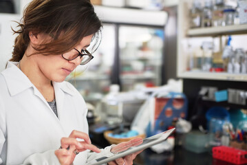 Science research student keeping track of data on a tablet.
