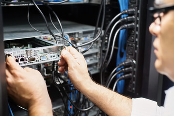 IT engineer extracting motherboard from data center server