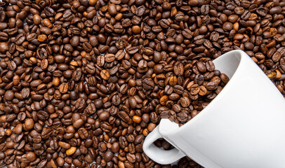 Arabika coffee beans background with coffee cup. Top view of Roasted Beans. copy space. food and drink concept.