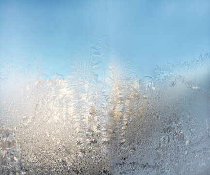 Frozen pattern on a cold window in Winter