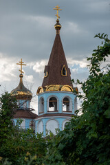 Fototapeta na wymiar St. Peter and Paul Russian Ortodox Church in Almaty, Kazakhstan. Rainy dramatic sky, golden towers