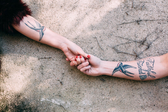 tattoed couple holding their hands