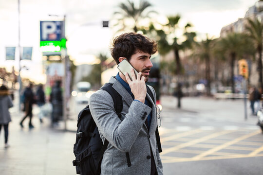Handsome businessman talking on phone on the street.