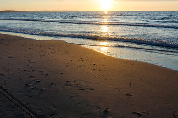 Sunset over the sea. Reflection of sunlight in the sea waves. The sky in the sunset rays.