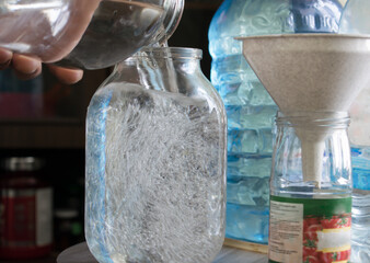 Moonshine in glass jar close up. The process of preparing moonshine