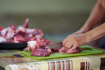 Woman's hand slicing beef on a wooden board