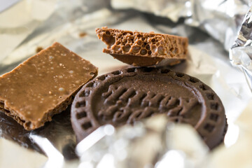 Two pieces of milk aerated chocolate with a round chocolate chip cookie