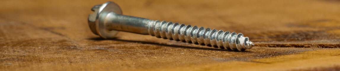 close-up screw on wooden background