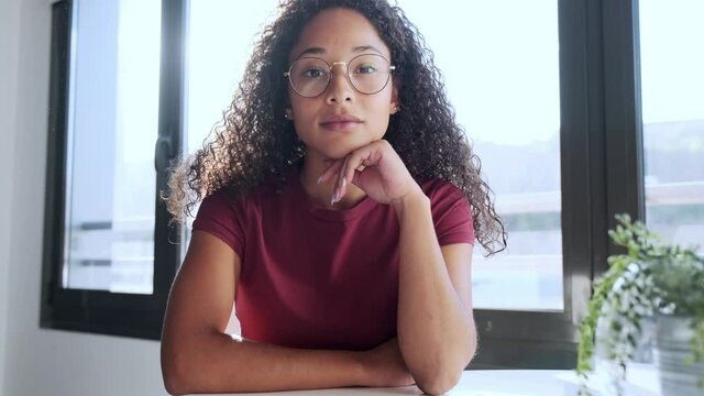 Video of beautiful african business woman looking and speaking through the webcam while making a video conference from the office.