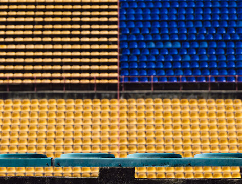 Empty out of focus blue and yellow seats on the stadium