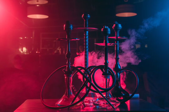 hookahs with shisha bowls and coals on the background of smoke in the restaurant