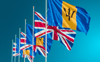 Obraz premium Waving flags of Barbados and the United Kingdom. A symbol of political and economic relations between UK Queen and Barbados.