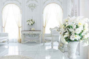 luxury royal posh interior in baroque style. very bright, light and white hall with expensive oldstyle furniture. large windows and stucco ornament decorations on the walls