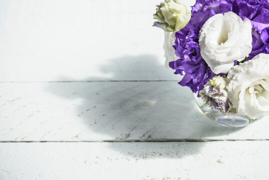 A bunch of eustoma flower on white sfurface with sunlight