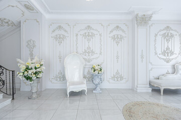 luxury royal posh interior in baroque style. very bright, light and white hall with expensive oldstyle furniture. large windows and stucco ornament decorations on the walls