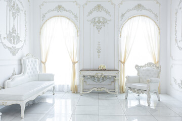 luxury royal posh interior in baroque style. very bright, light and white hall with expensive oldstyle furniture. large windows and stucco ornament decorations on the walls