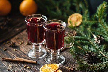 festive homemade hot mulled wine with Christmas decor and spices on a wooden table